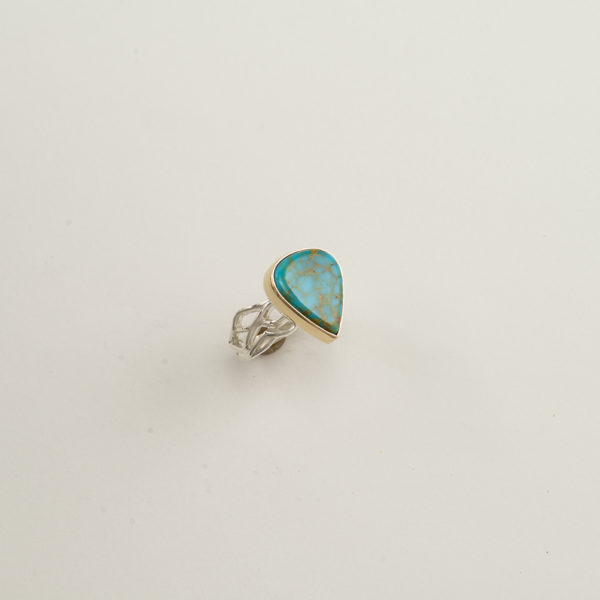 This Kingman turquoise ring is a one-of-a-kind. The ring shank was made with sterling silver. The turquoise has been set a 14kt yellow gold bezel. Shown in a size 7, but can be re-sized.