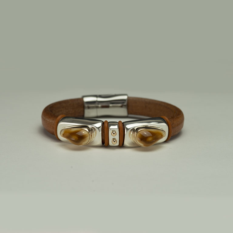 Here is an elk ivory bracelet with silver and gold. The clasp is a magnetic stainless steel on a tan leather. Shown in a size 7.75, but can be re-sized. 