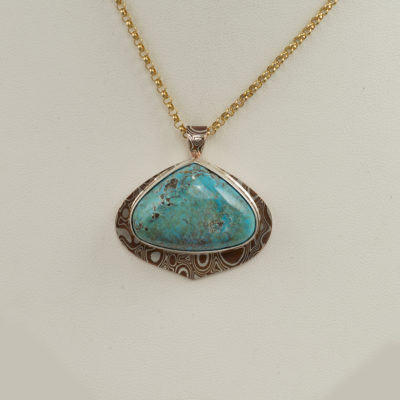 This turquoise pendant was set in SS and has mokume gane accents. The turquoise is from the kingman mine and the chain is included in the price.