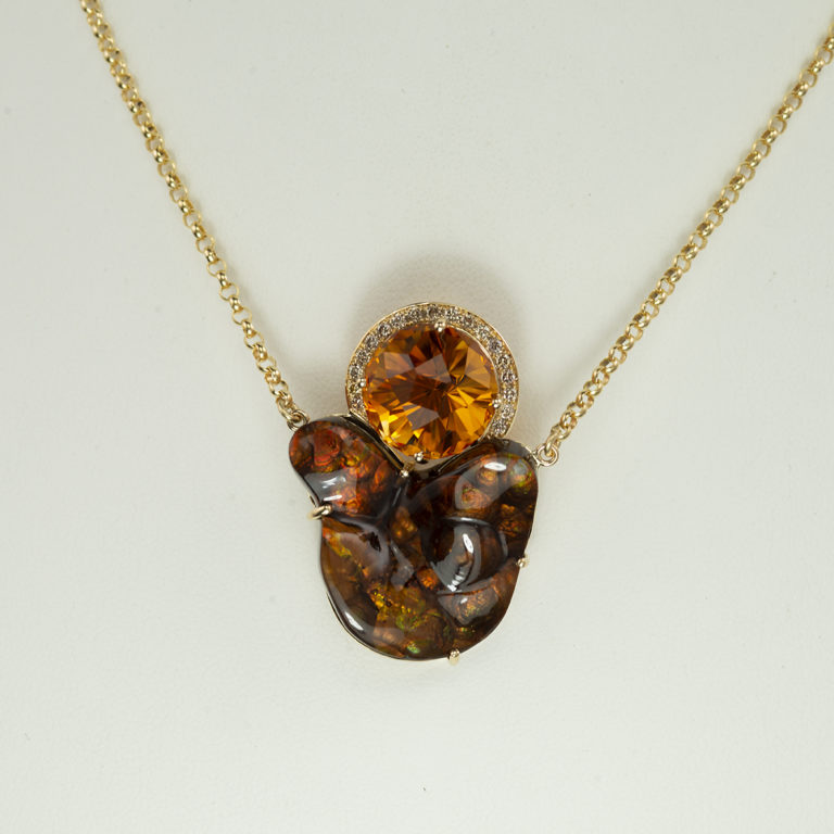 This fire agate pendant has citrine and diamond accents. All of the stones have been set in 14kt yellow gold. The chain has a lobster claw clasp.