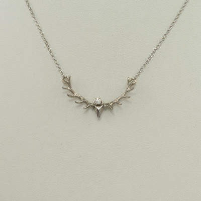 This white gold antler pendant has a white diamond accent. The diamond is a round, brilliant-cut. The chain is included and has a lobster claw clasp.