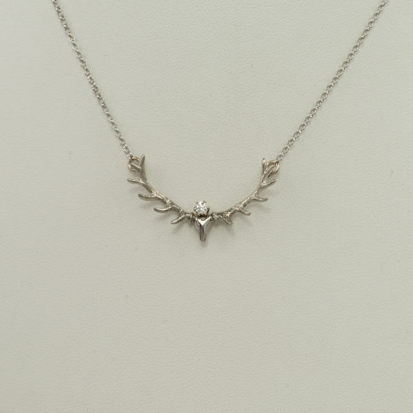 This white gold antler pendant has a white diamond accent. The diamond is a round, brilliant-cut. The chain is included and has a lobster claw clasp.