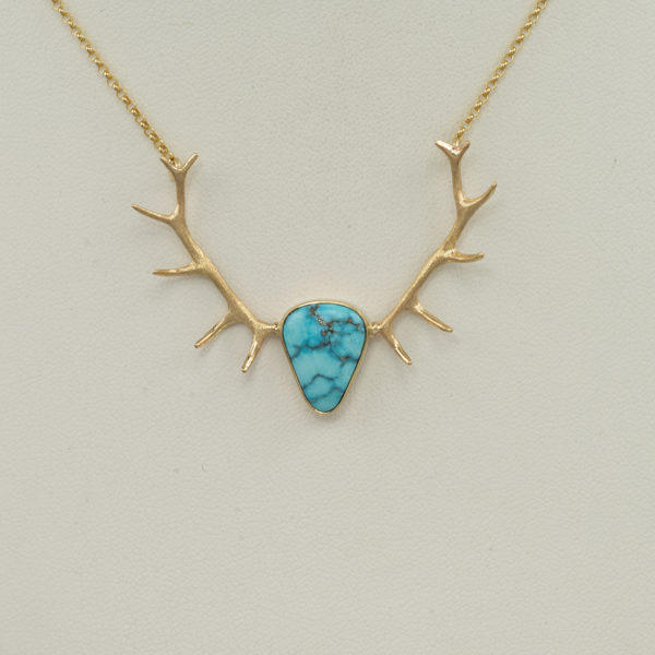 This Kingman pendant was cast in 14kt yellow gold. The antlers have a textured finish and the bezel has a polished finish. The chain is 16" in length.