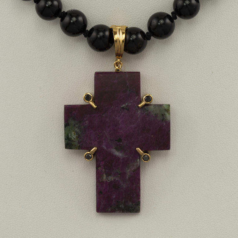 This zoisite cross is one of a kind. The cross has been set in sterling silver with a 14kt yellow gold plate. Black diamond accents are the finishing touch.