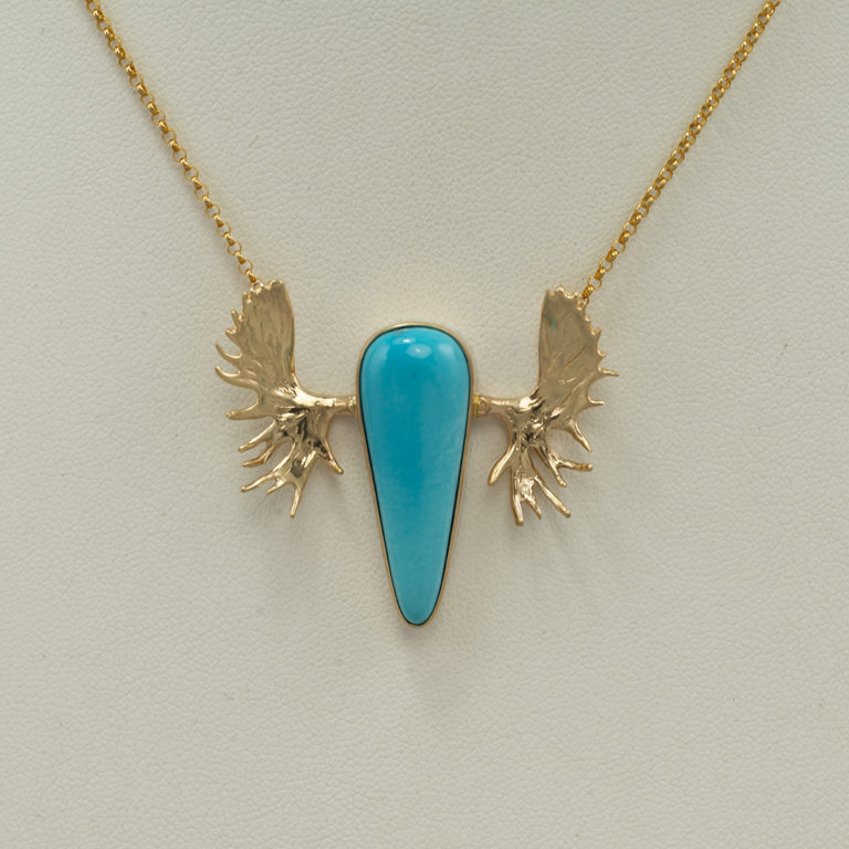 Here is a turquoise moose pendant in 14kt yellow gold. The turquoise is natural Sleeping Beauty and was cut by Dan Harrison. The chain is 16" in length and has a lobster claw clasp. 