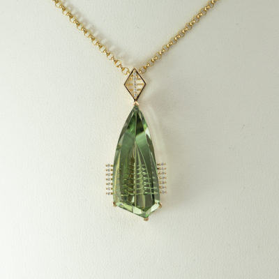 This Prasiolite pendant has diamond accents. Both the prasiolite and the diamonds have been set in 14kt yellow gold. The prasiolite is a "fantasy cut" stone and the diamonds are round, brilliant cut. The chain is not included in the price.