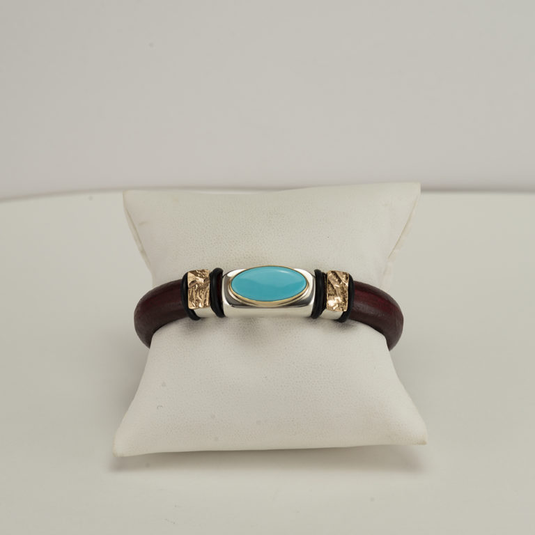 This Sleeping Beauty cuff was made using leather, silver and gold. It has a magnetic stainless steel clasp and is a size 7.25, but can be re-sized.