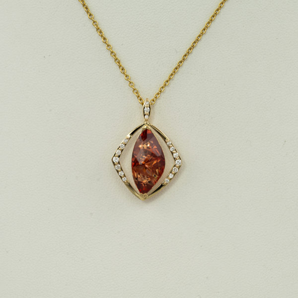 Here is an Oregon Sunstone pendant. The sunstone was cut by Alexander Kreis. Accenting the sunstone are brilliant cut diamonds. Both the diamonds and the sunstone have been set in 18kt yellow gold. The chain is sold separately. 