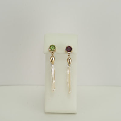 These long pearl earrings have been set in 14kt yellow gold. Our designer has used green and pink tourmaline along with diamonds to accent the pearls. The pearls are fresh water. These are one of a kind. 