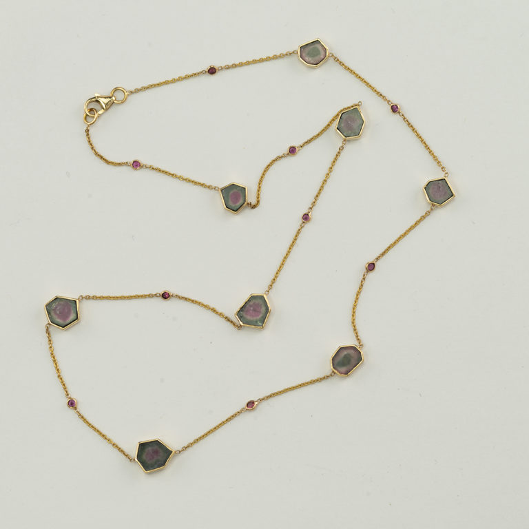 Here is a tourmaline slice necklace in 18kt yellow gold. The slices have been cut into hectogons. The length is adjustable.