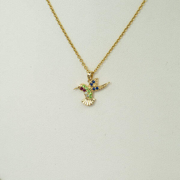 Small hummingbird pendant in yellow gold with gemstones.