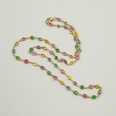 This sapphire and emerald necklace has been set in 18kt yellow gold. The length is 18" and it has a lobster claw clasp. Over 14cts of gemstones.