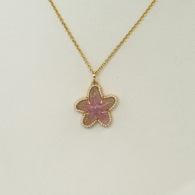 This starfish pendant is one-of-a-kind. The starfish is a bi-color tourmaline that has been set in yellow gold. Chain not included.