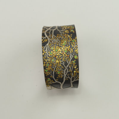 This aspen cuff was created by Wolfgang Vaatz. Made entirely by hand and set with diamonds and garnets. Shown in a size M/L.