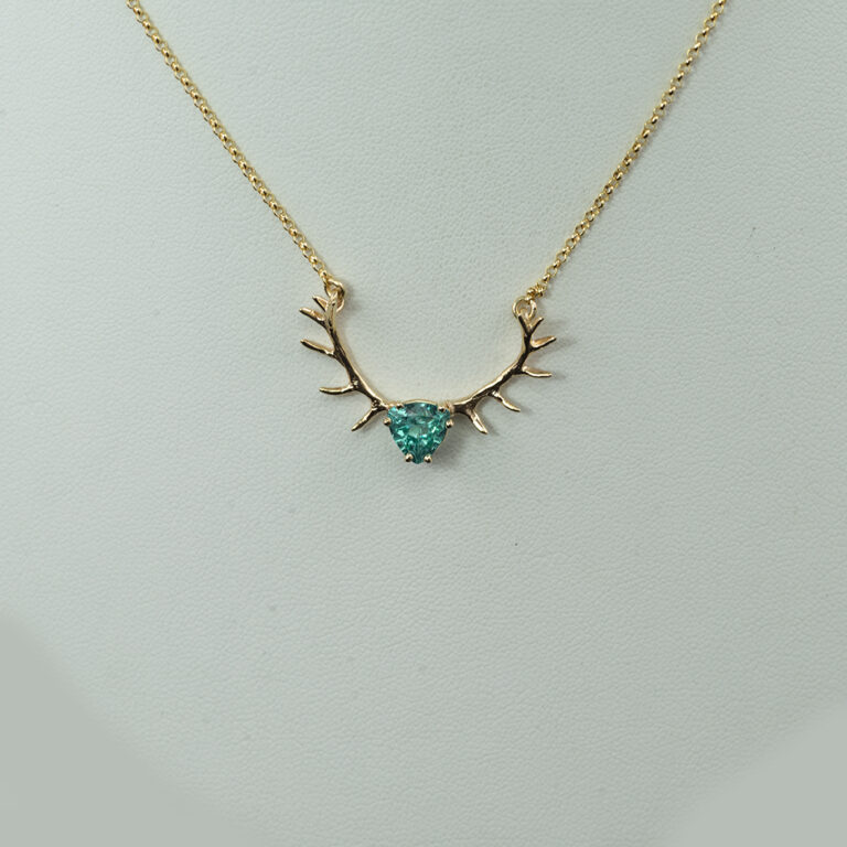 This apatite antler pendant is one-of-a-kind. The apatite is a trillion cut and set in a yellow gold crown.  The antlers crown and chain are 14kt gold.