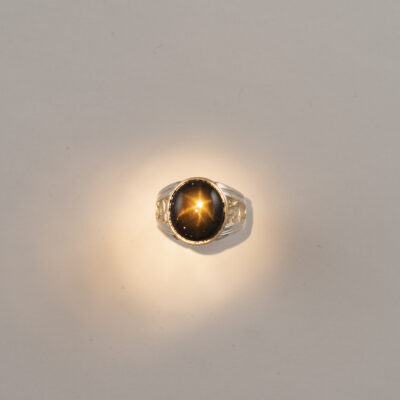 Here is a Men's star sapphire ring. The star sapphire is black and is 24.0cts. The ring has been made using 14kt yellow gold and sterling silver.