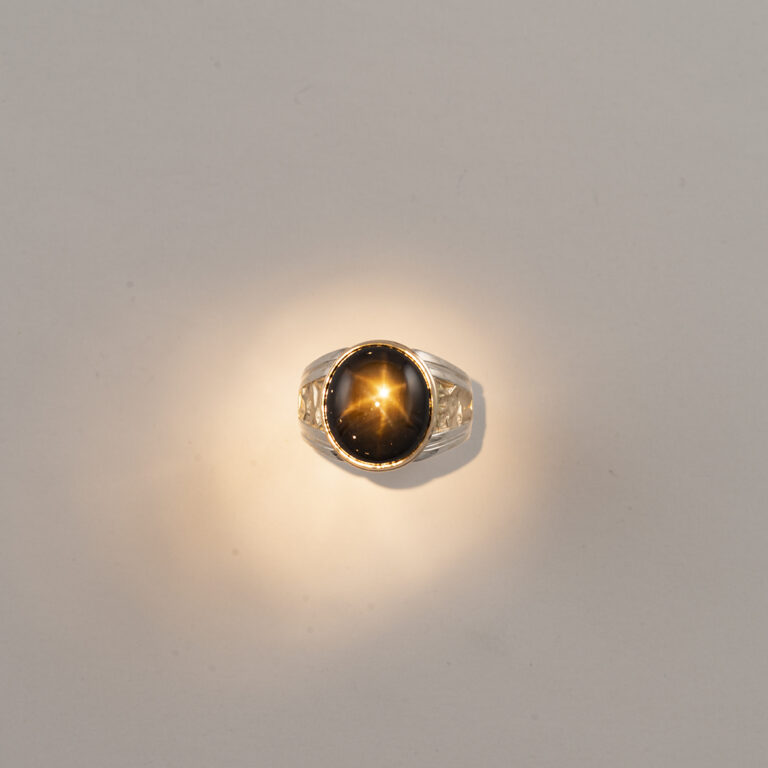 Here is a Men's star sapphire ring. The star sapphire is black and is 24.0cts. The ring has been made using 14kt yellow gold and sterling silver.