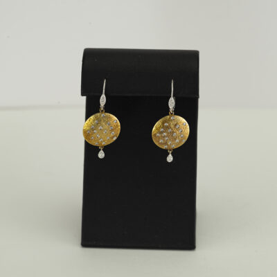 These Meira T earrings have been made with white and yellow gold. Both the white and the yellow gold are 14kt. Set in the gold are round diamonds.