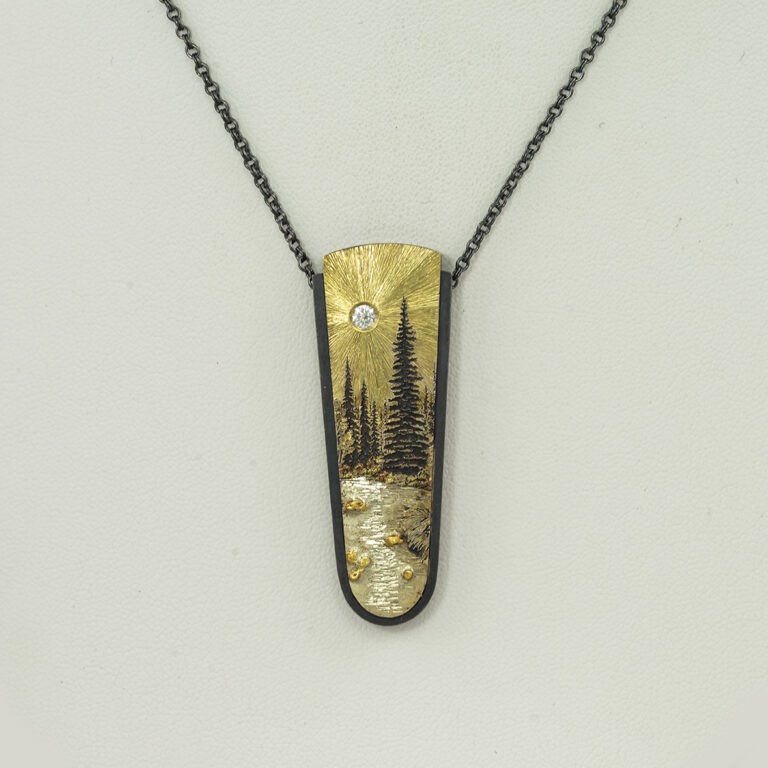 This mountain stream pendant was handcrafted by Wolfgang Vaatz. Made with sterling silver, 18kt yellow gold, placer gold and a white diamond accent.