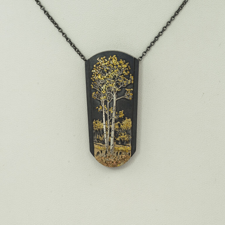 This aspen grove pendant was created by Wolfgang Vaatz. It is a combination of argentium silver, sterling silver, 14kt rose gold and placer gold.