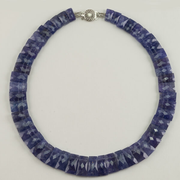 Here is a Tanzanite necklace. It is one of a kind with a 14kt white gold clasp. The Tanzanite is reversible from a smooth finish to a faceted finish.