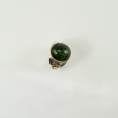 This men's tourmaline ring is two tone. Made with sterling silver and 14kt yellow gold. Shown in a size 10, but can be re-sized.