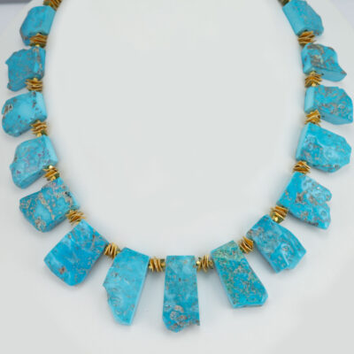 This raw sleeping beauty turquoise necklace is one-of-a-kind. The sleeping beauty turquoise has been cut into "plates". Accenting the turquoise plates are 24kt gold fill discs. The necklace is 18" in length. 