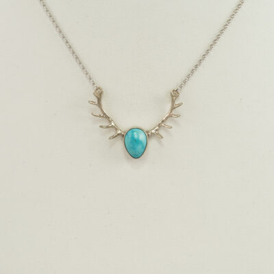This turquoise and antler pendant is one-of-a-kind. The turquoise is from the Kingman mine. The antlers, chain and bezel are all 14kt white gold. The length is 17" and the chain has a lobster claw clasp.