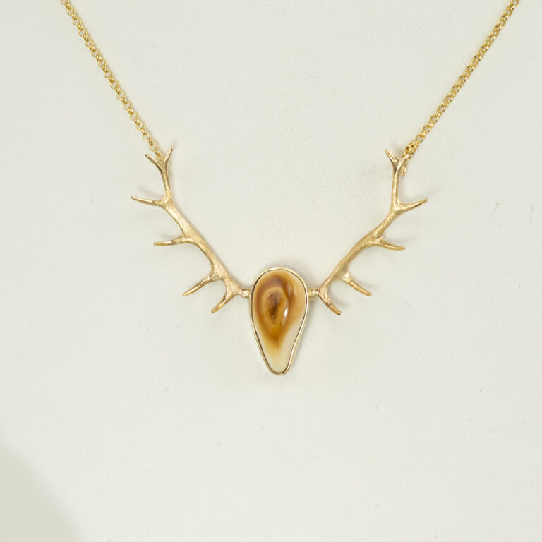 This antler pendant with ivory was made with sterling silver and 14kt yellow gold. The elk ivory is from a bull and the chain is 16", but fits like a 17".