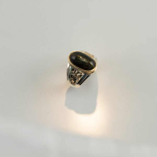 This men's star sapphire ring is one of a kind. It has been made using sterling silver  and 14kt yellow gold.  Shown in a size 10.75, but can be re-sized.