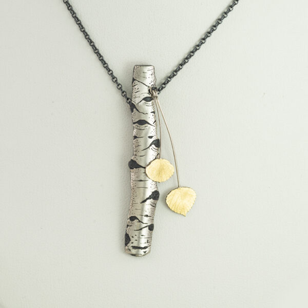 Here is a two tone aspen pendant. The aspen leaves move independently of the bark. The gold leaves are 18kt bi-metal. The chain is adjustable and this pendant is made in America.
