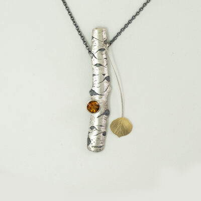 This is a two tone aspen pendant with citrine. The silver is argentium, the gold is 18kty bi-metal and the citrine is a round cut. Made in America with an adjustable chain.