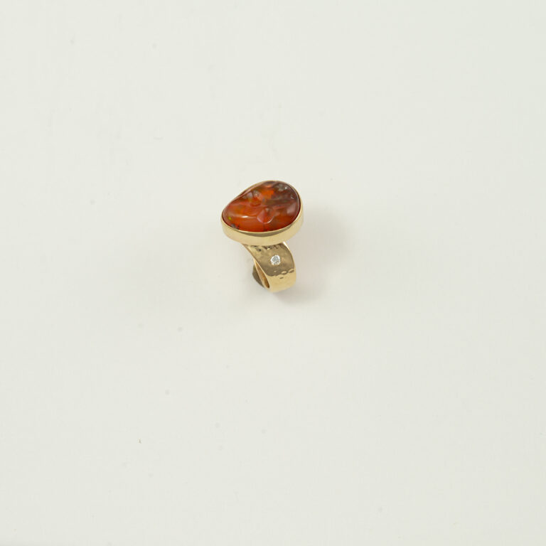 Here is a fire opal ring. Accenting the fire opal are faceted, white diamonds. Both the fire opal and the diamonds have been set in 14kt yellow gold. Shown in a size 6.25, but can be re-sized. 