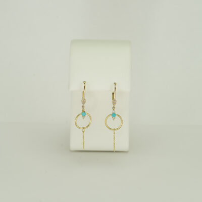 This pair of turquoise and gold earrings has diamond accents. The diamonds are round-cut and set in 14kt yellow gold. 