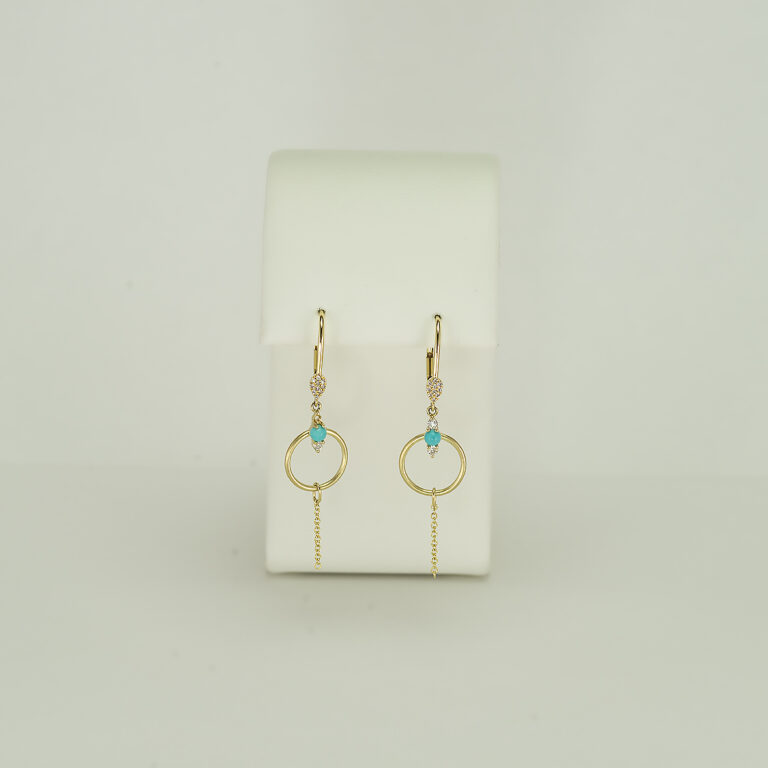 This pair of turquoise and gold earrings has diamond accents. The diamonds are round-cut and set in 14kt yellow gold. 