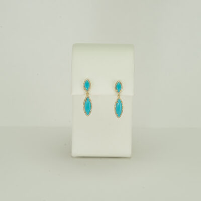 These marquise turquoise earrings have diamond accents. Both the diamonds and the turquoise have been set in 14kt gold. Designed by Meira T.