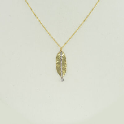 This leaf pendant was designed by Meira T. It has been made with 14kt white and yellow gold. Accenting the two tone gold are brilliant cut, white diamonds.