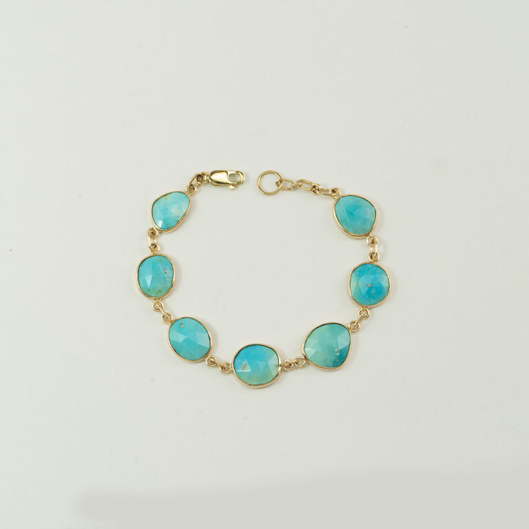 This turquoise bracelet in gold is one-of-a-kind. The turquoise has been top-faceted. The gold is 14kt. Shown in a size 7.