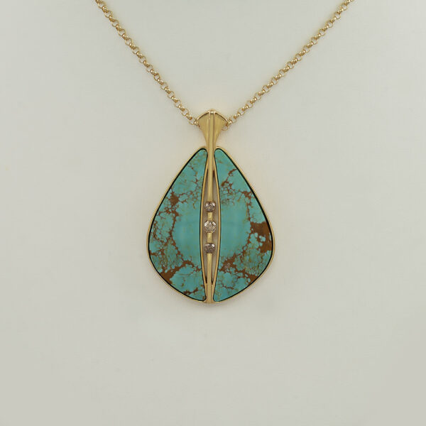 This Nevada turquoise pendant had diamond accents. The diamonds are champagne in color and round cut. The plating is 14kt yellow gold.