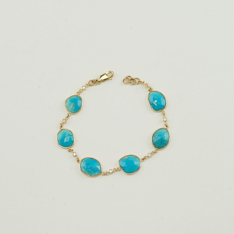This turquoise and diamond bracelet is one-of-a-kind. Both the turquoise and the diamonds have been set in 14kt yellow gold. Shown in a size 7.