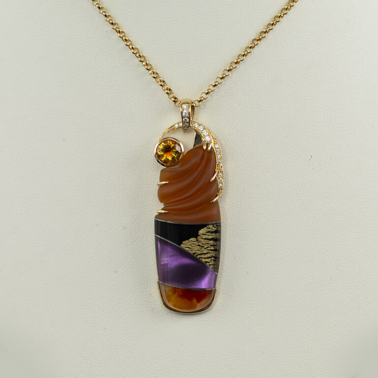 This sculpted pendant is a one-of-a-kind. The sculpted portion of the piece features carved carnelian, black jade, 24kt gold leaf, and black onyx on quartz.