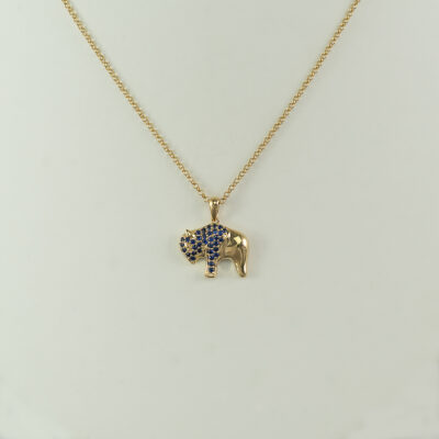 This bison pendant with sapphires has been made with yellow gold. The gold is 14kt and the chain is sold separately.
