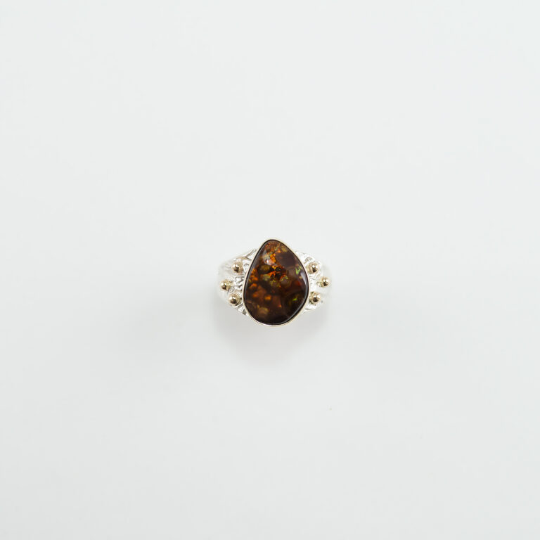 Fire agate ring with sterling silver and 14kt yellow gold in a size 10. This is a one of a kind ring designed by the owner of the gallery.
