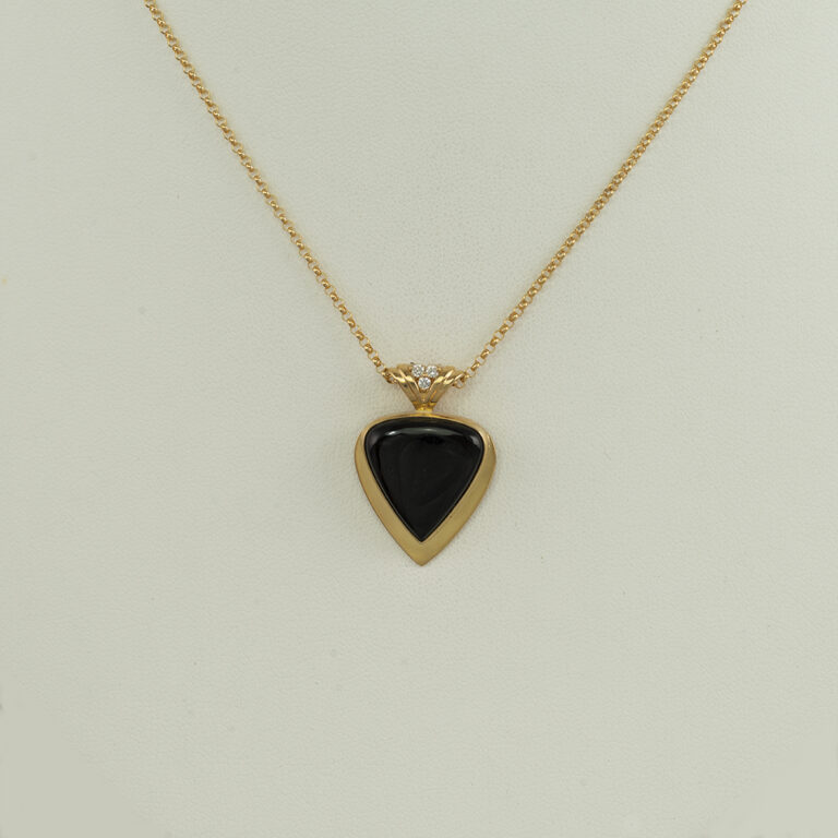Here is a gold and black jade pendant. The jade is from Wyoming and accenting the jade is a brilliant-cut diamond. The chain is sold separately. 