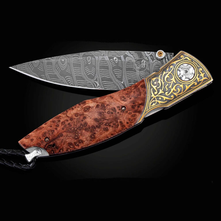 The Omni 'Redwood' features a frame in 24K gold Koftgari, inlaid with Redwood burl wood. The blade is hand-forged 'Hornets Nest' damascus by Chad Nichols.