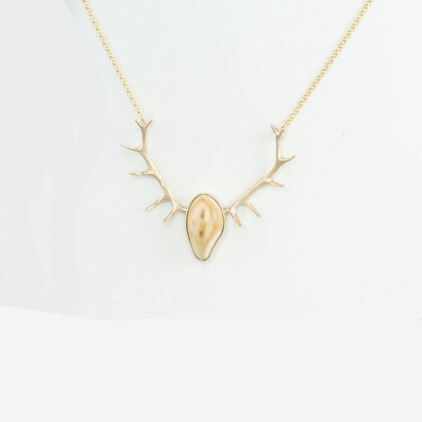 This elk ivory antler pendant has been made using 14kt yellow gold. It has a sterling silver backplate. The length is 18" and the chain has a lobster claw clasp.