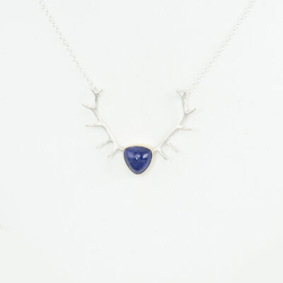 Here is a tanzanite and antler pendant. The tanzanite has been set in 14kt yellow gold. The antlers, chain and clasp are solid sterling silver. Length is approximately 17-18". This piece is one-of-a-kind.