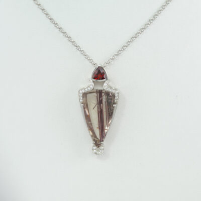 This quartz pendant was made with Sterling silver. The quartz has red rutile needles running through it. The chain is included and has a lobster claw clasp.