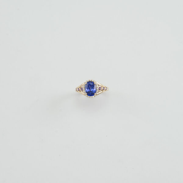 This tanzanite ring is one-of-a-kind. Accenting the oval-cut Tanzanite are white and purple diamonds. All the stones have been set in 14kt yellow gold.